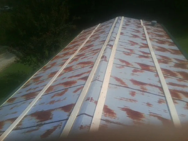 Rusted metal roof panels with new wood purlins before replacement — Storm Damage Roof Repair in Utica by Roofing Brothers